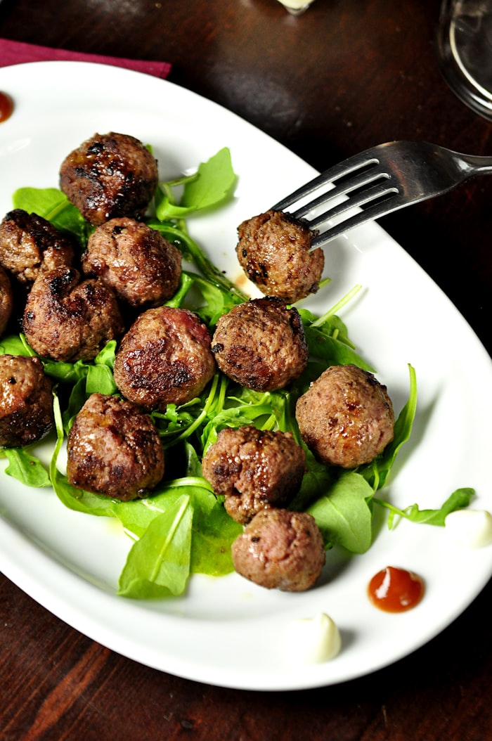 Glossy sweet and tangy cocktail meatballs served with party toothpicks