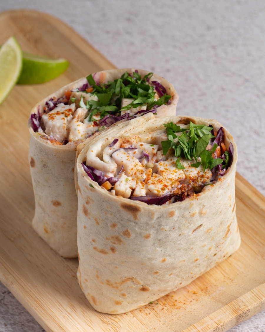 Sliced breakfast burrito showing scrambled eggs, cheese, beans, and sausage