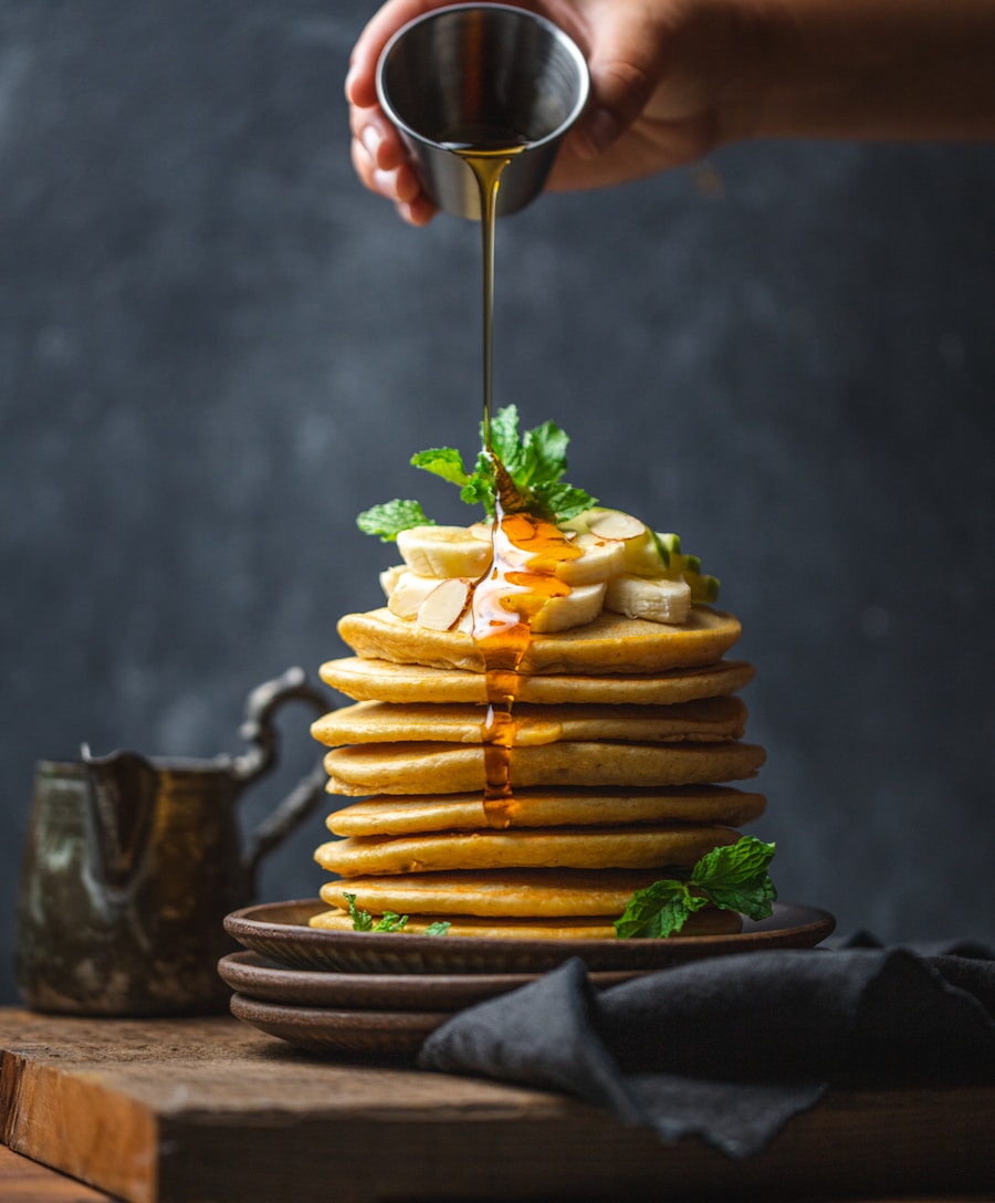 Stack of golden cornmeal pancakes with melting butter and maple syrup
