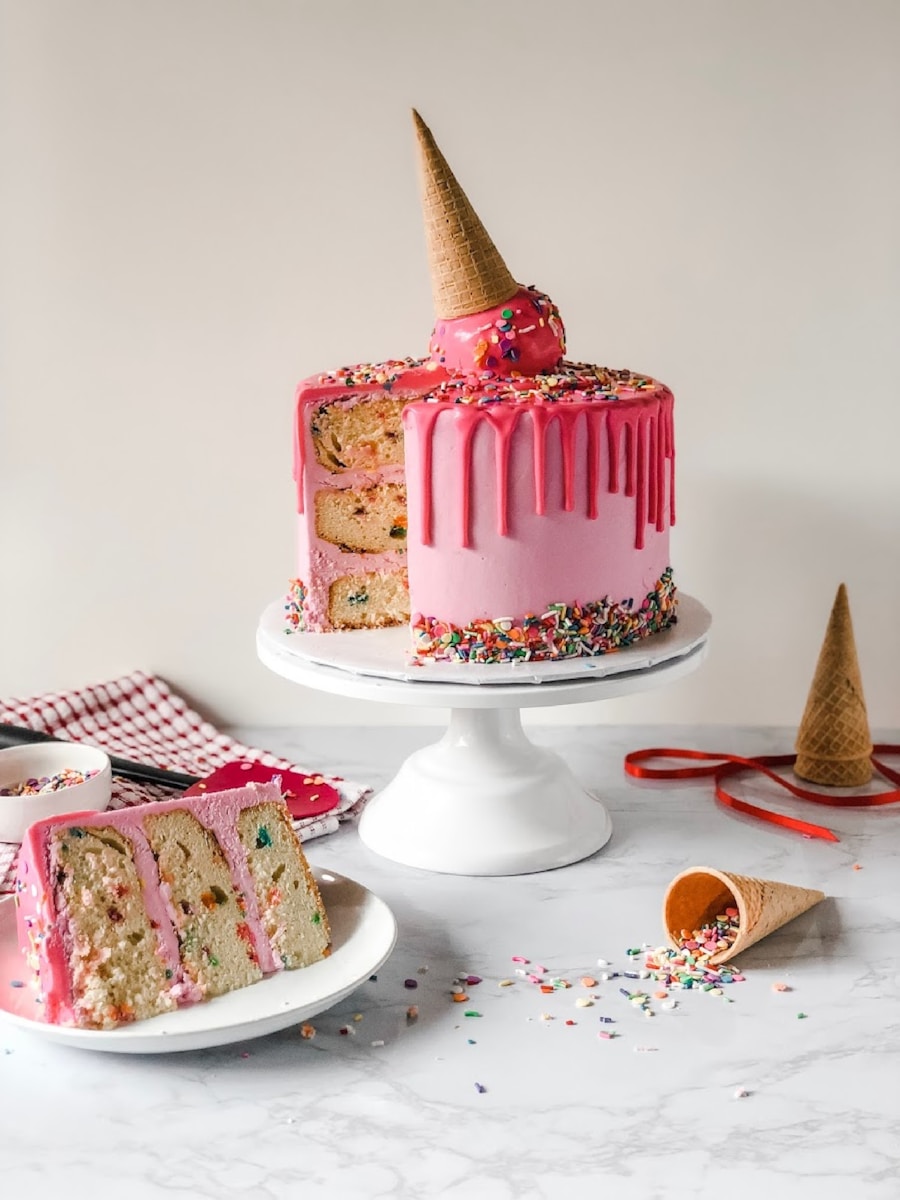 Thick slice of moist spiced carrot cake crowned with fluffy cream cheese frosting on ceramic plate