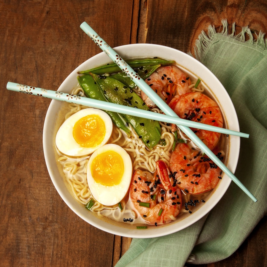 Chilled Japanese buckwheat soba noodles swirled in a pink ceramic bowl with green scallions