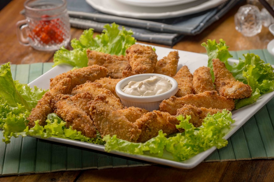 Plate of golden crispy baked cauliflower nuggets with a bowl of red marinara dipping sauce